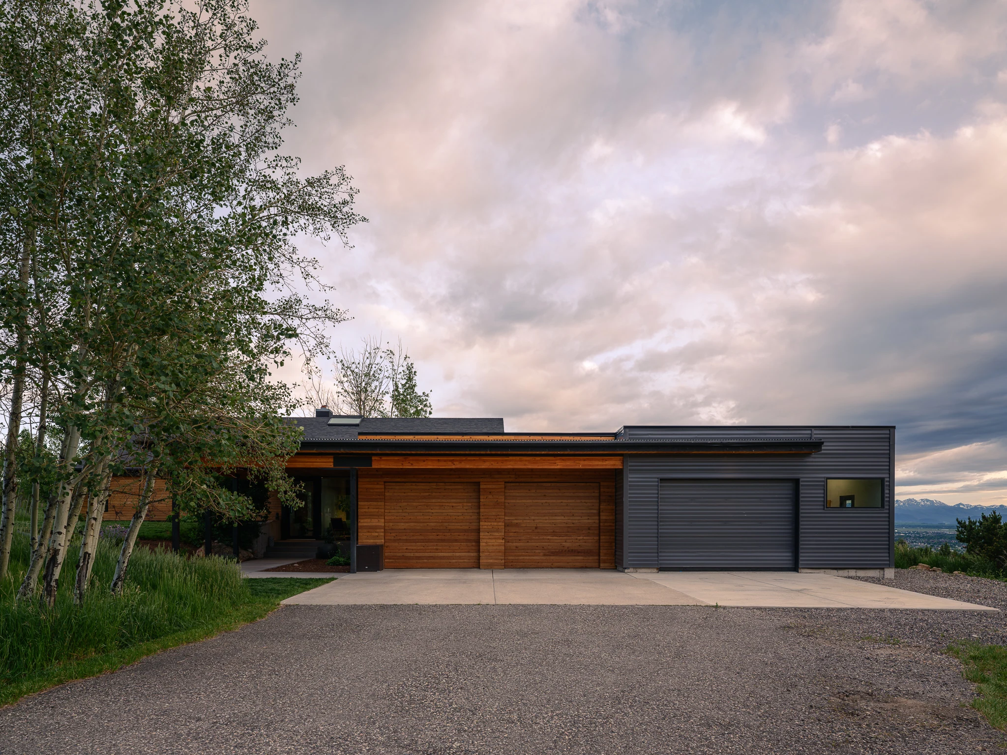Front elevation with wood garage doors at dusk — architectural photography Bozeman Montana, Bozeman Overlook